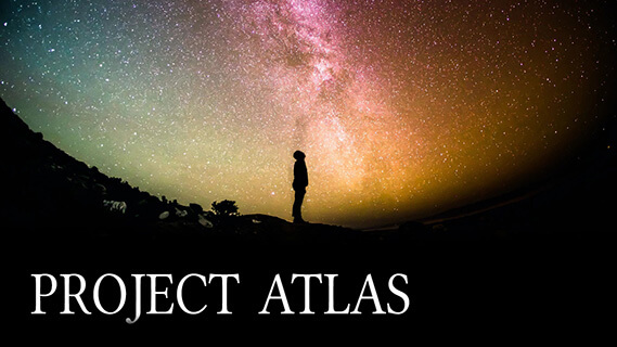 The silhouette of a man on a hill, standing before a starry background.